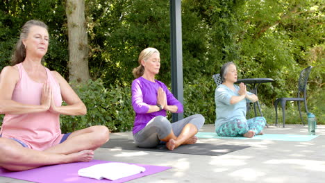 senior diverse group of women practicing yoga outdoors