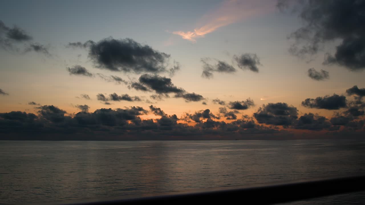 Serenity at Sea: View from Ship Moving Through Calm Waters Bathed in the Warm Glow of the Sunset