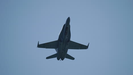 silhouette of military jet aircraft flying in slow motion above with visible vapor condensation formation, filmed in slow motion