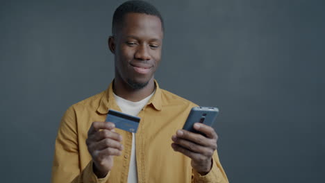 man using mobile phone and credit card for online shopping