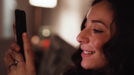 Young-Italian-woman-smiles-while-going-through-her-smart-phone