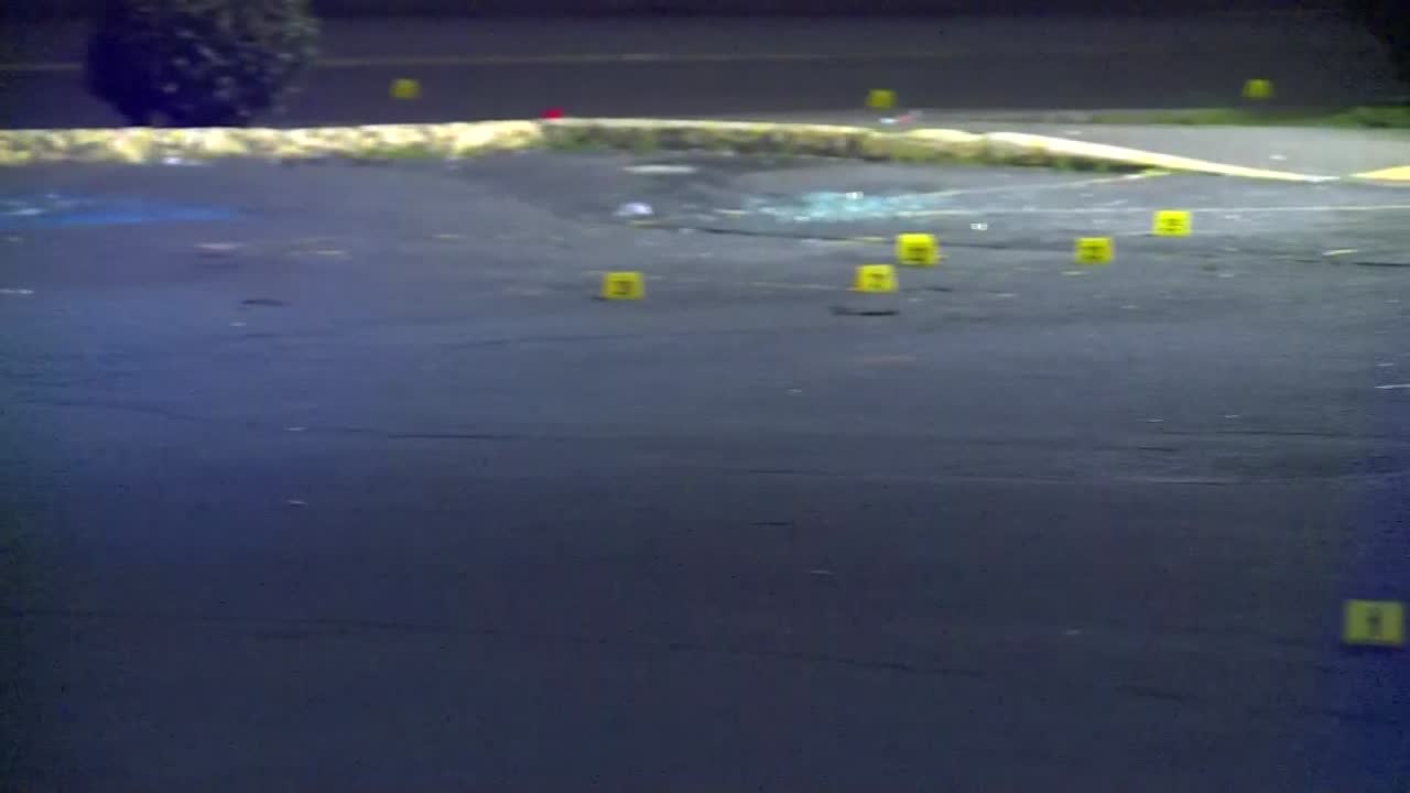 PANNING SHOT AT NIGHT FROM POLICE CAR TO POLICE MARKERS AT CRIME SCENE