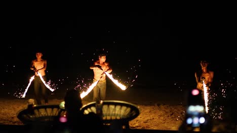 fire dancers on the beach at night