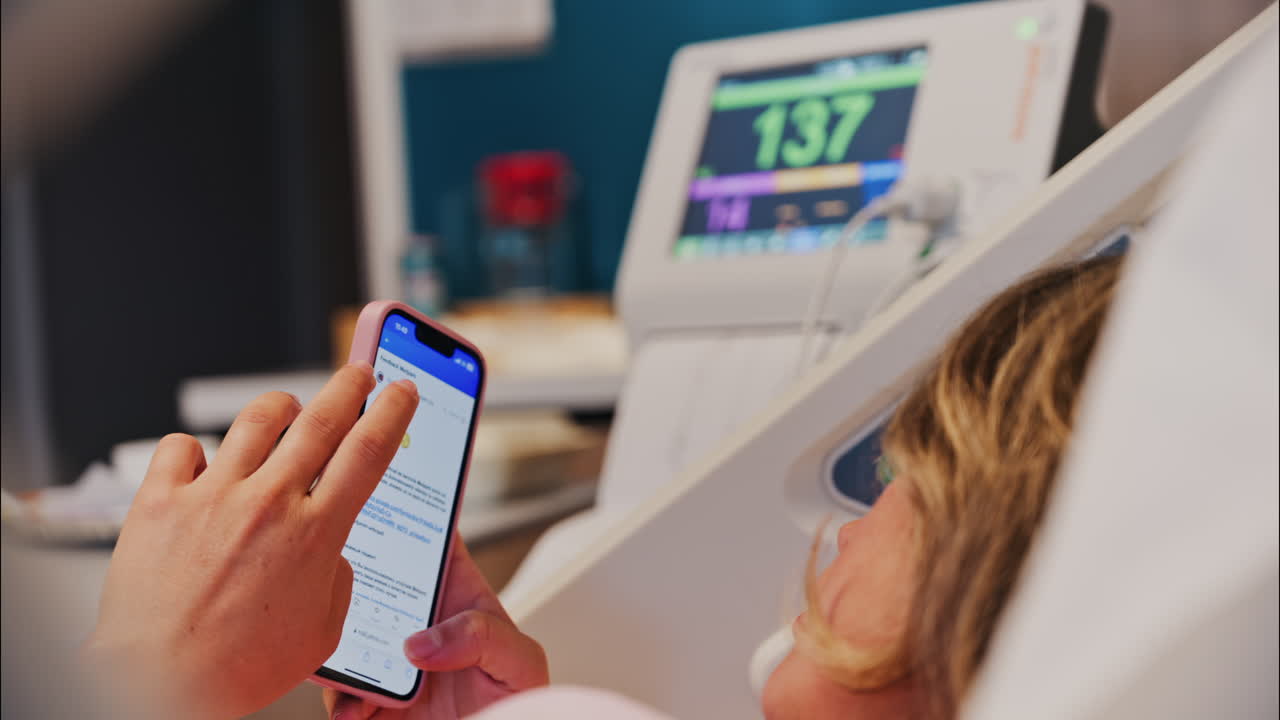 Chisinau, Moldova - May 31, 2025: Pregnant woman scrolling on her phone while doing a prenatal check-up at the doctor's office