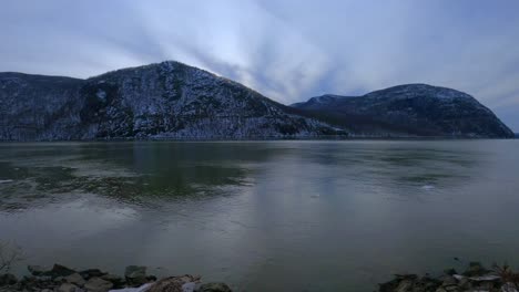 lapso de tiempo de nubes gong sobre una montaña nevada y un río helado en las montañas apalaches durante el invierno