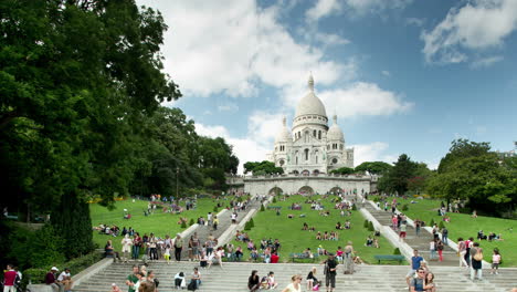 sacre coeur cathedral in paris with tourists on the steps