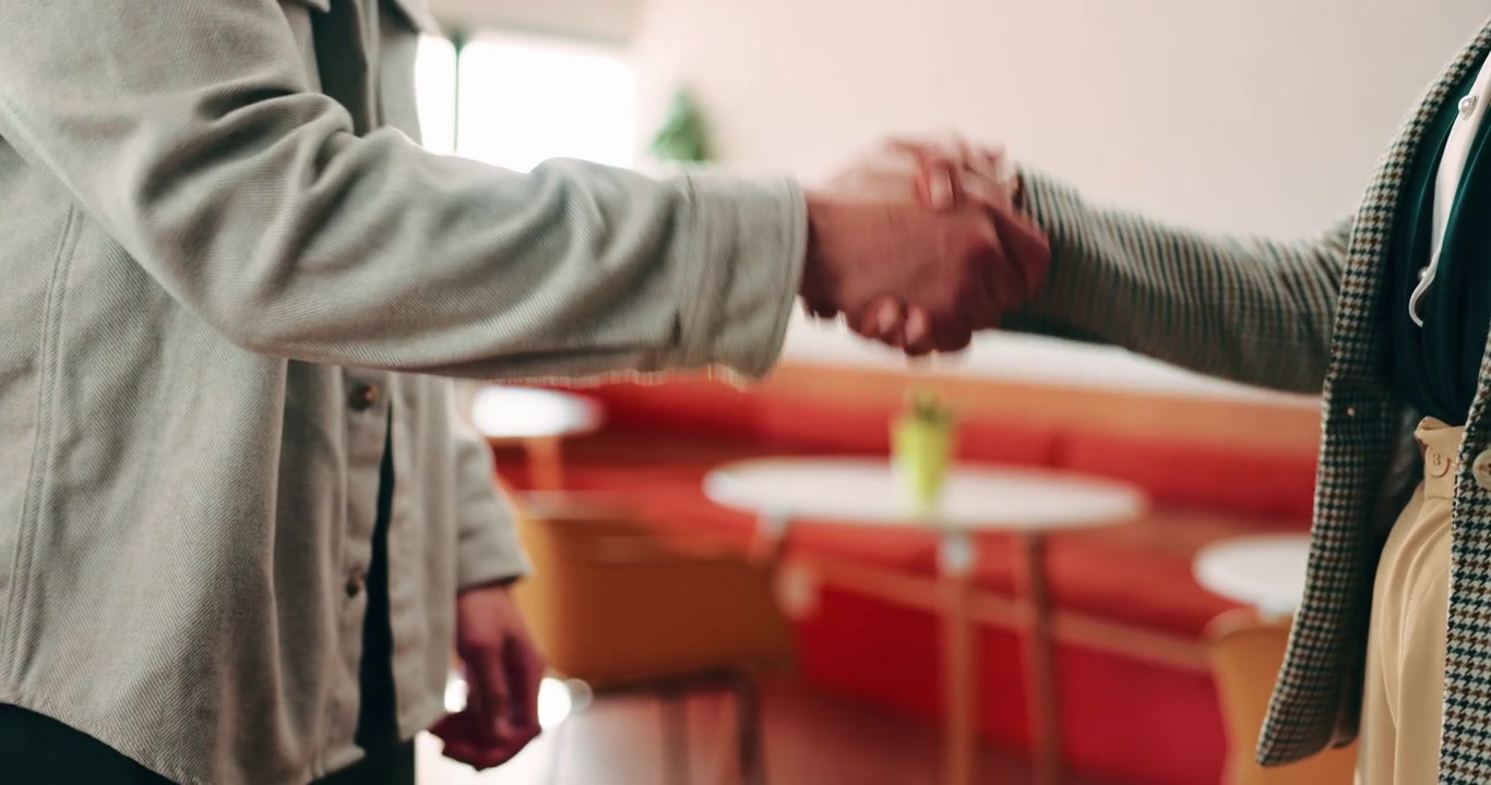 Due professionisti che si stringono la mano in un ufficio moderno