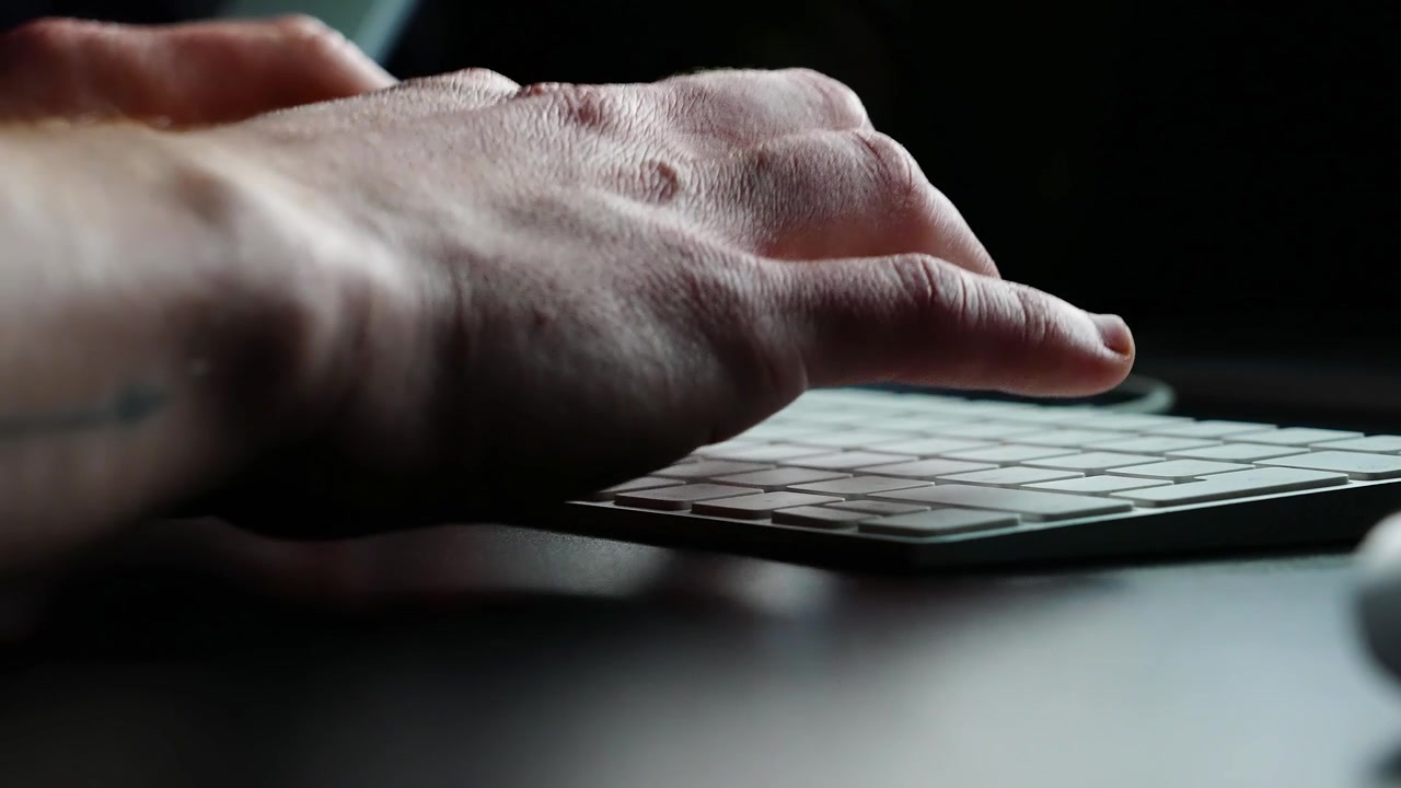 Focused Creative Working on a Sleek Keyboard, Capturing the Essence of Digital Editing in a Contemporary Environment