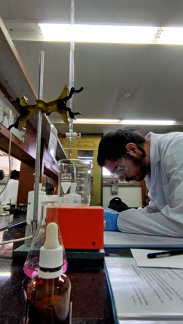 male researcher in lab reading scientific papers