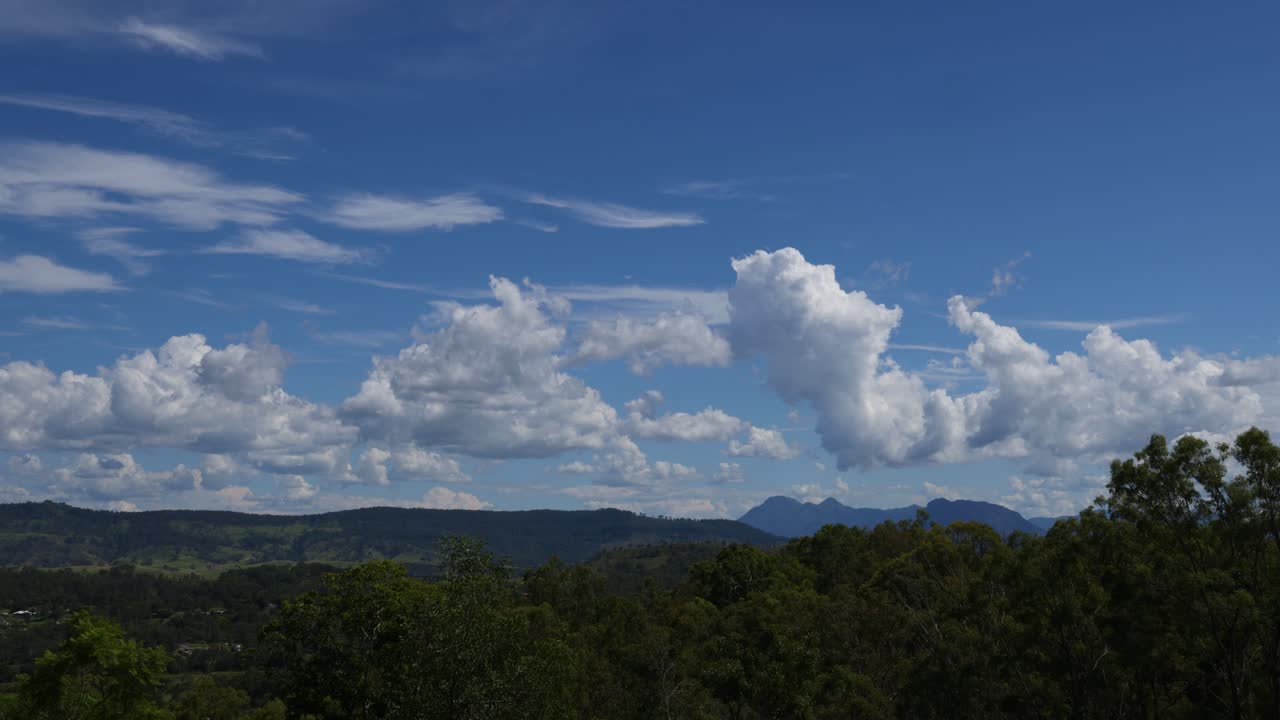 산악 지형 위의 하늘을 가로질러 움직이는 구름