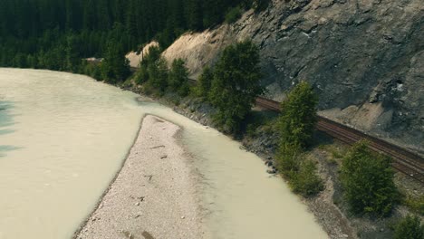 Drone-shot-Kicking-Horse-River-in-Canadian-Rockies-in-British-Columbia-with-rail-line-running-next-to-it