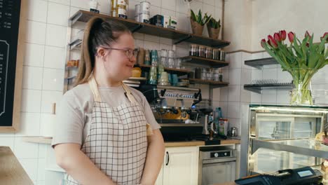 mujer caucásica con síndrome de down que se va a llevar comida a una cliente femenina