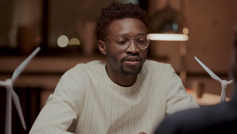 black engineer explaining ideas for renewable energy project to colleague