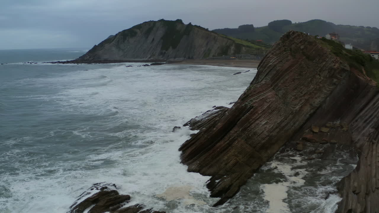las olas del océano chocan contra acantilados en ángulo rocas flysch en la playa de itzurun españa
