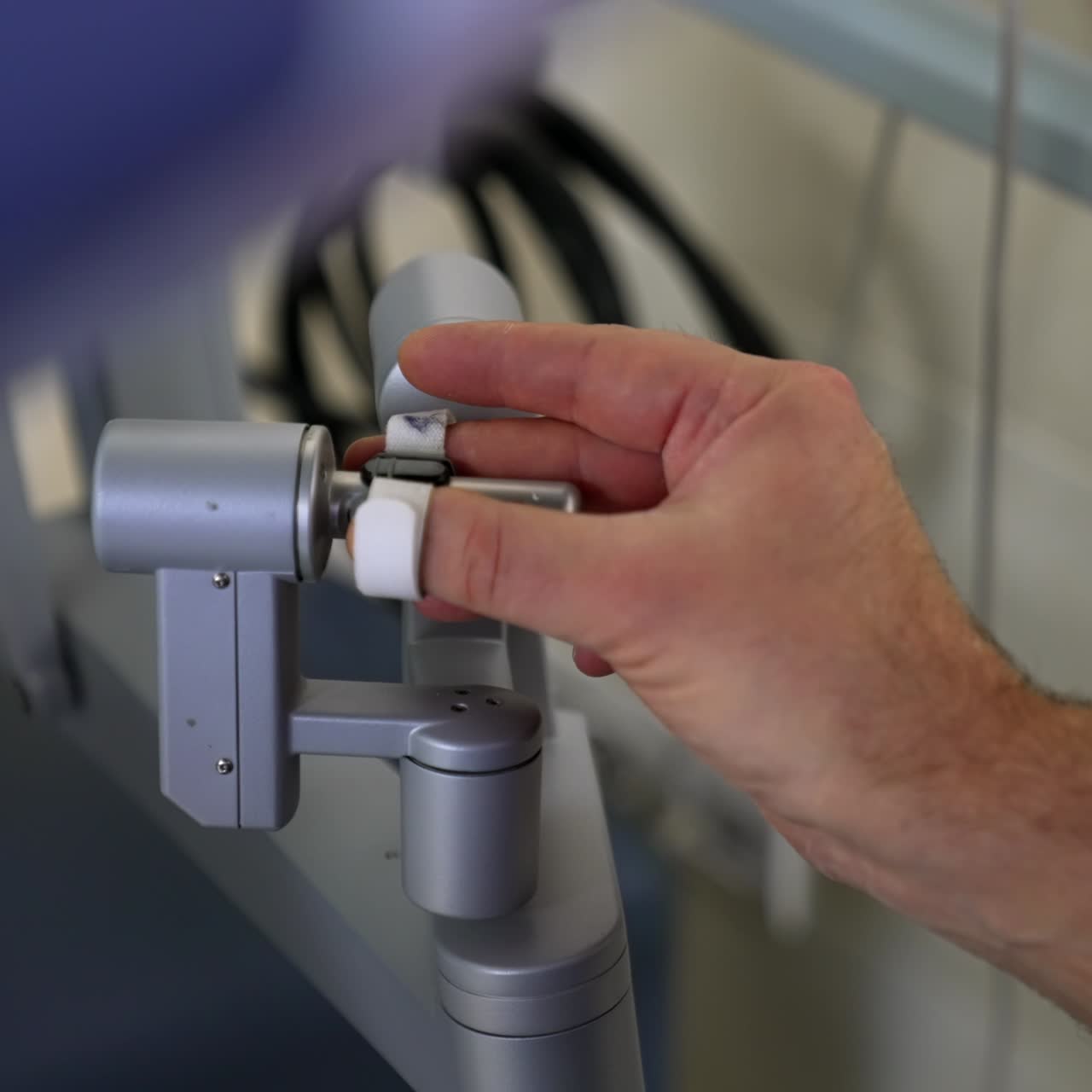 Bare male hands directing the manipulation controllers of robotic equipment. Surgeon conducting surgery with the help of technology. Close up