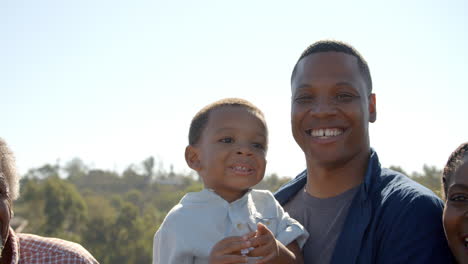 handheld pan of happy multi generation black family outdoors