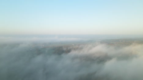Dramatischer-Luftflug-über-Morgennebelwolkenumkehrung-über-Ländliche-Landschaftshügel