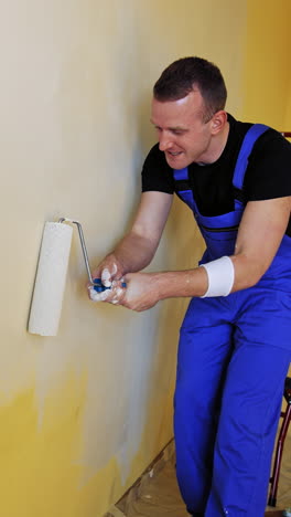 new style renovation. workman in the uniforms painting the walls with paint roller in a house. construction roller painting walls. vertical video