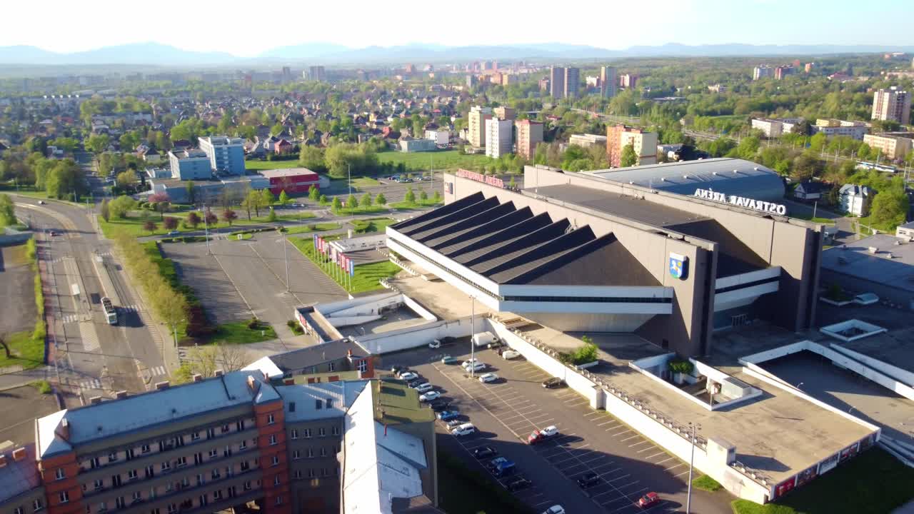 Aerial establishing pullback view of Ostravar Arena, focusing on the multifunctional hall and surrounding area