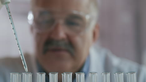 científico gota líquido en un tubo de ensayo y sacudiendo en el laboratorio. pipeta goteando una sustancia química de color en tubos de ensayo. primer plano del hombre de la ciencia trabajando. imágenes de alta calidad 4k