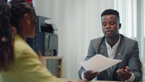 happy confident black woman recruit handshaking employer getting hired at new job. smiling young female professional manager shake hand of black man client or customer making business office meeting