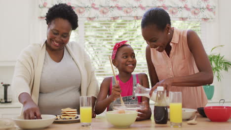 African-american-grandmother,-mother-and-daughter-preparing-dinner-in-the-kitchen-at-home