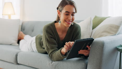 Woman,-smile-and-lying-of-sofa-with-tablet