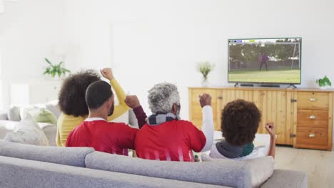 video of african american family sitting on sofa and watching football at home