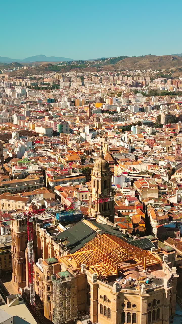 Vertikal dronekredsning omkring Málaga Katedral, gotisk arkitektur i en historisk by under en klar solrig middelhavsdag, Spanien.