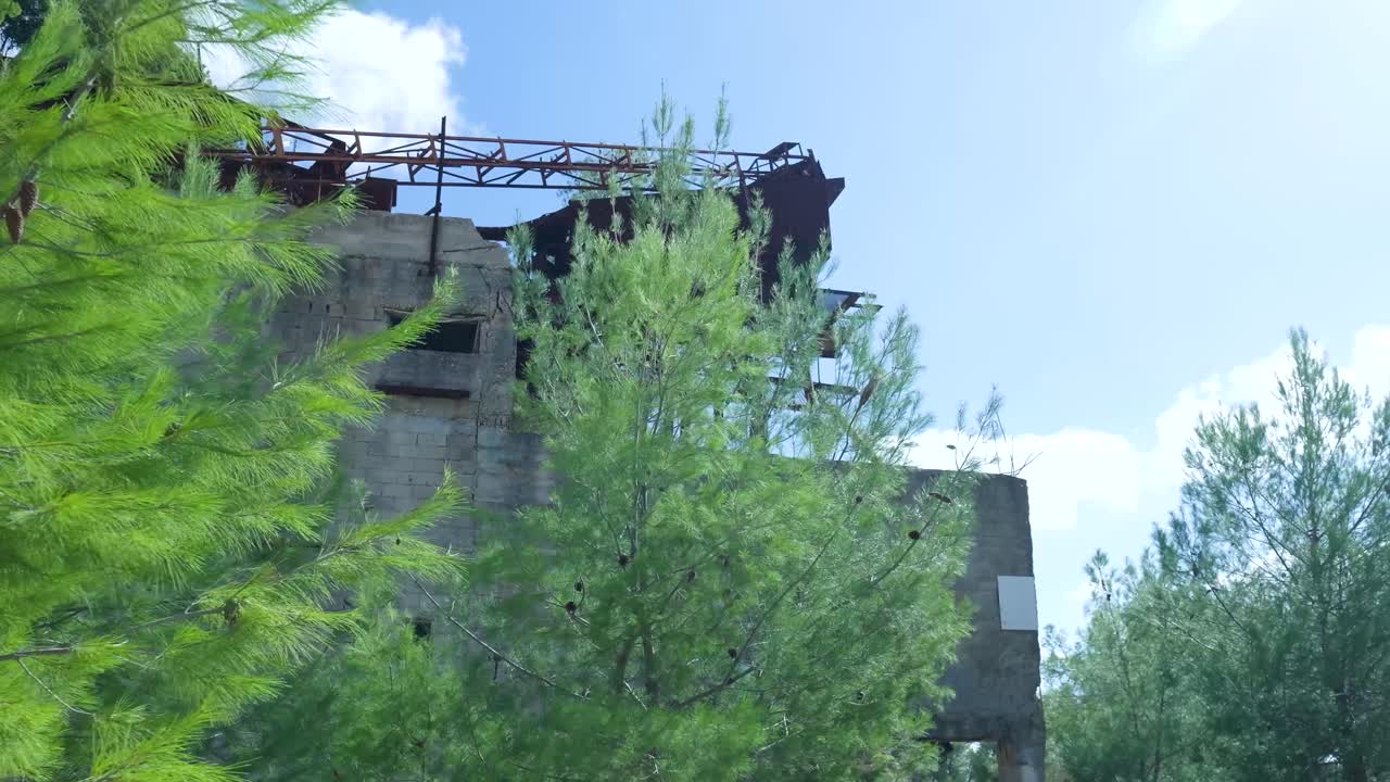 edificio industrial abandonado con metal oxidado y árboles