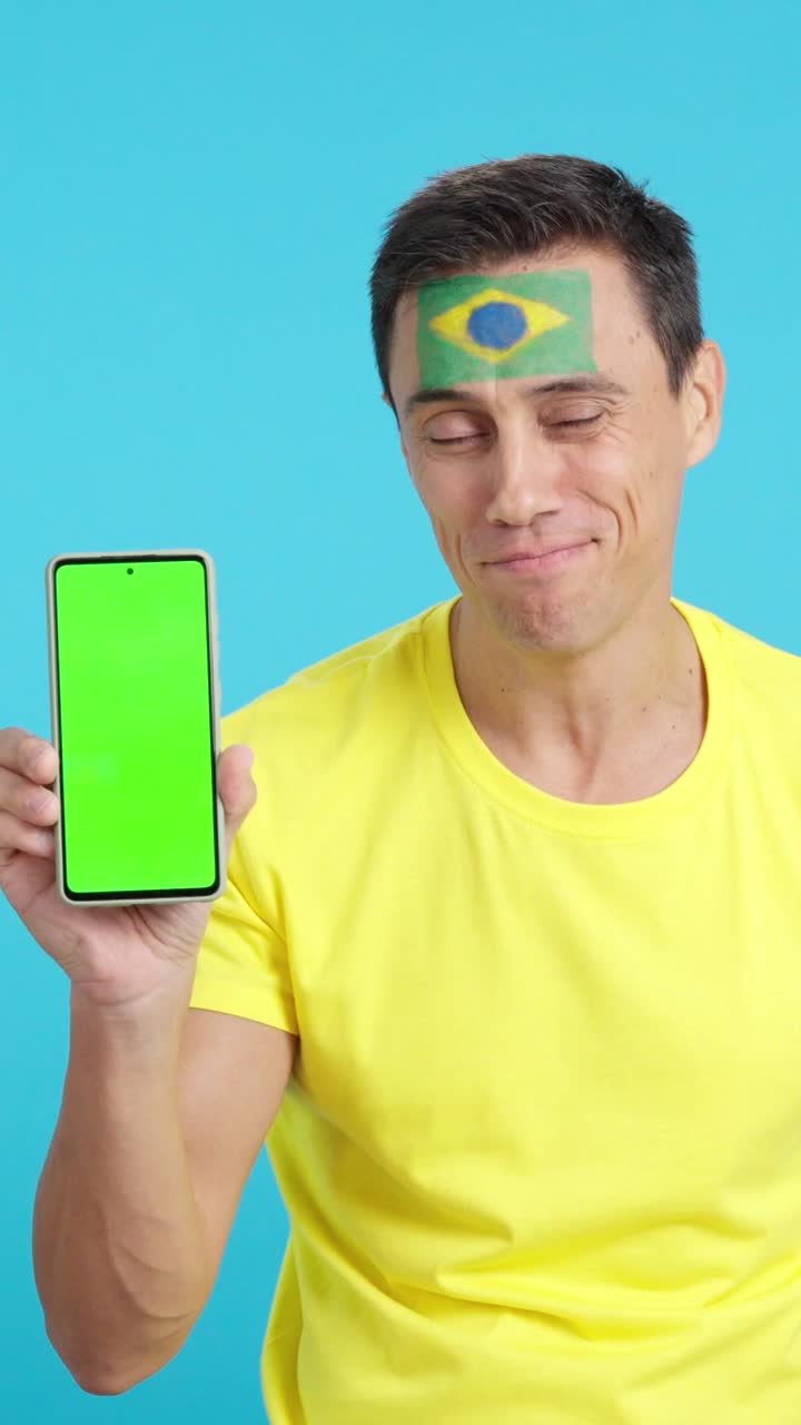 Brazilian man looking at his mobile smiling and showing it