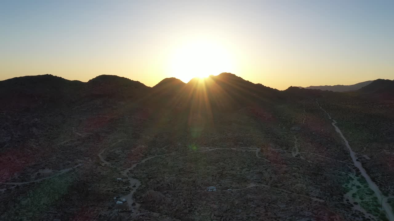 전경에 사막 풍경이 있는 산 위에 밝은 황금빛 일몰