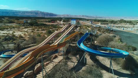 drone-shot-of-a-Couple-sitting-on-a-water-slide-in-an-abandoned-park