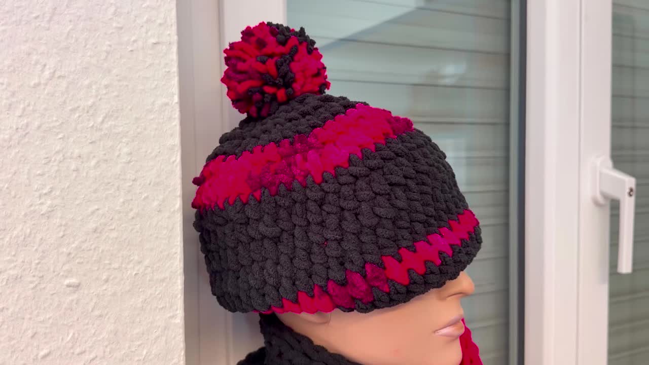 The head of a mannequin is covered with a red and black striped cap, slow orbit closeup shot