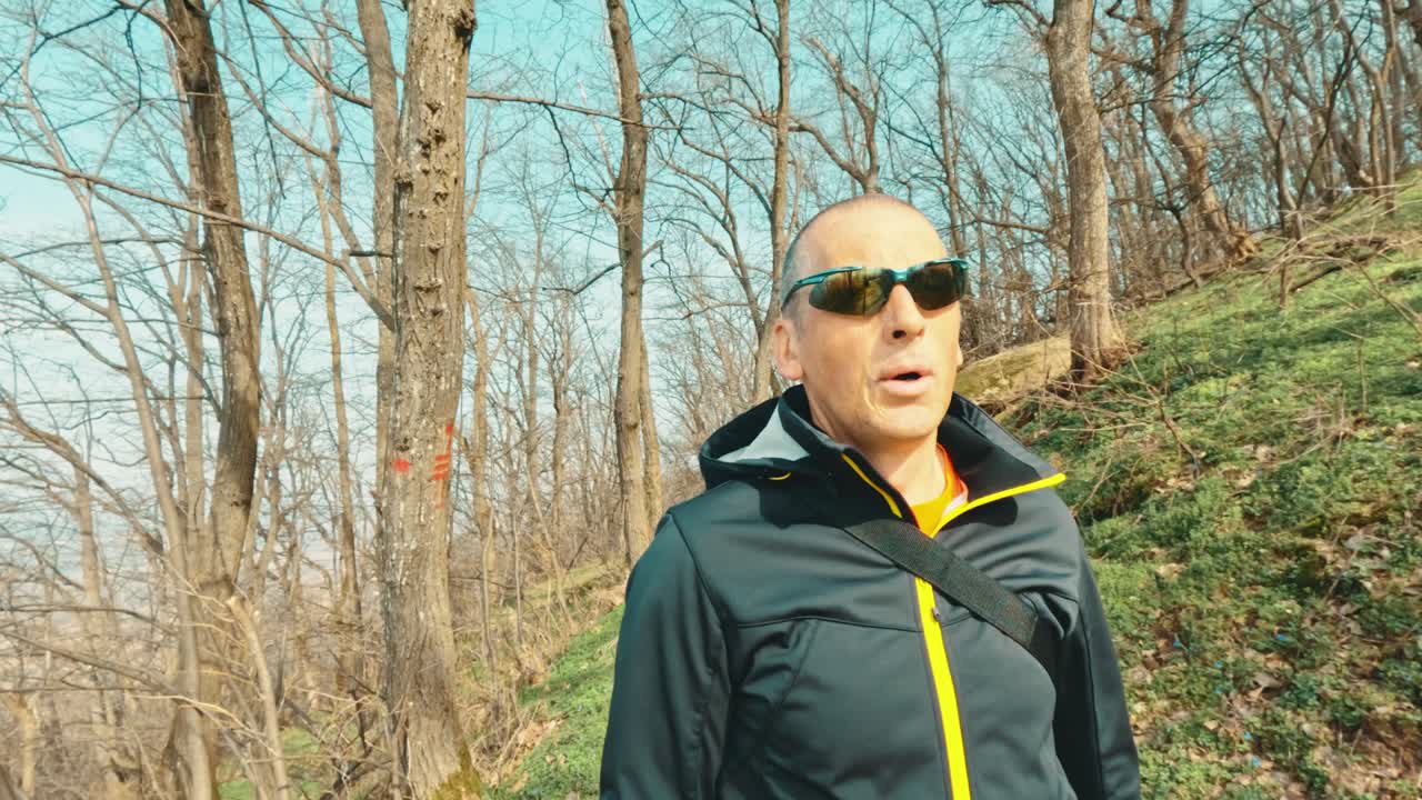 Stylish senior man in a sporty jacket exploring a forest trail. Authentic representation of active aging, vitality, and modern elderly lifestyle