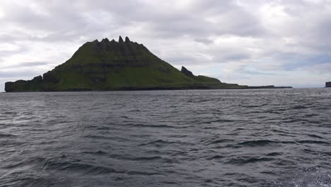 View-from-a-moving-boat-in-the-ocean-of-Tindholmur-peaks-in-Faroe-Island