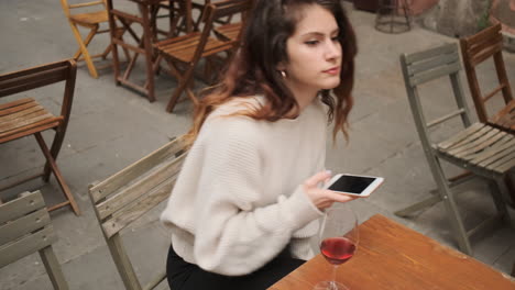 Brünette-Frau-Benutzt-Smartphone-Auf-Einer-Terrasse