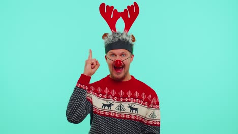 Excited-man-in-Christmas-sweater-make-gesture-raises-finger-came-up-with-creative-plan-good-idea