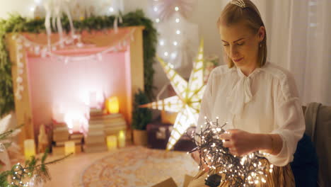 woman untangling christmas lights in cozy living room