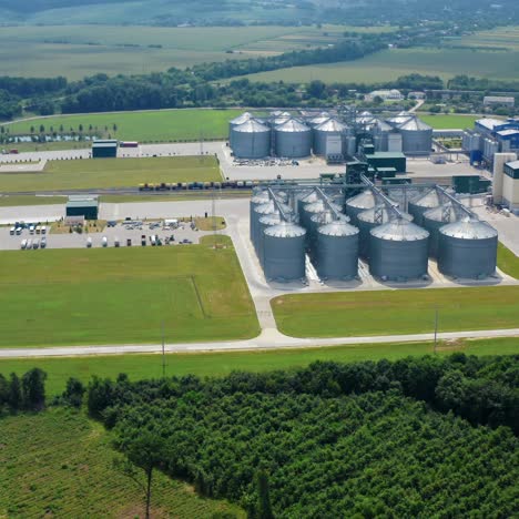 grain elevators in agricultural zone. granary with mechanical equipment for receiving, cleaning, drying grain. modern agricultural complex surrounded with beautiful landscape. aerial view