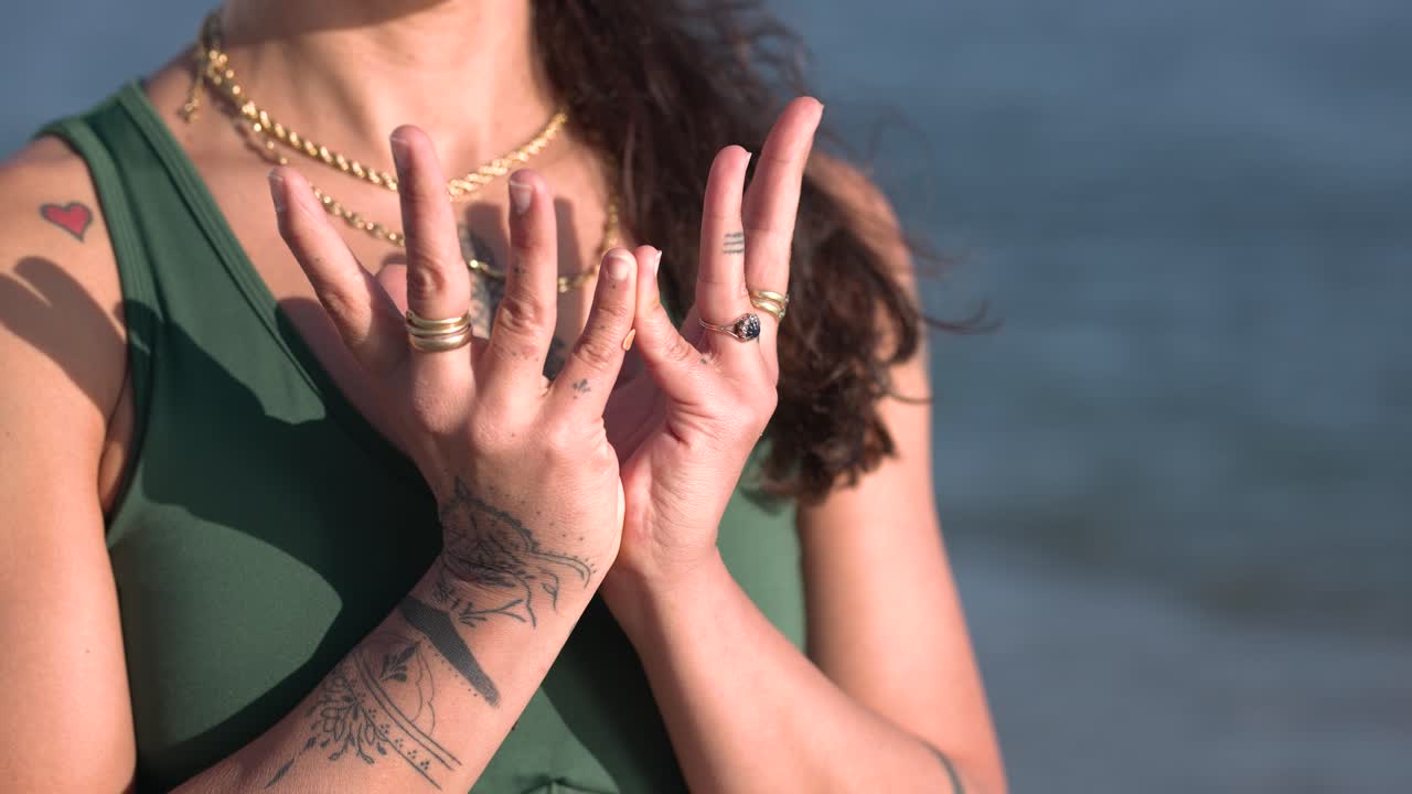 Woman performing ksepana mudra by the sea