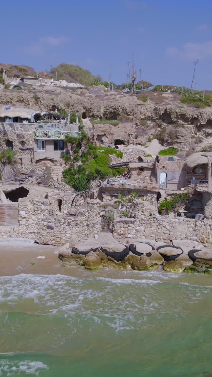 The Artistic House - Sidna Ali Beach is a Beautiful complex made of stones on a cliff next to a distant beach - parallax Vertical shot