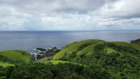 green hills and ocean on a cloudy day in baras, catanduanes, philippines - aerial drone shot