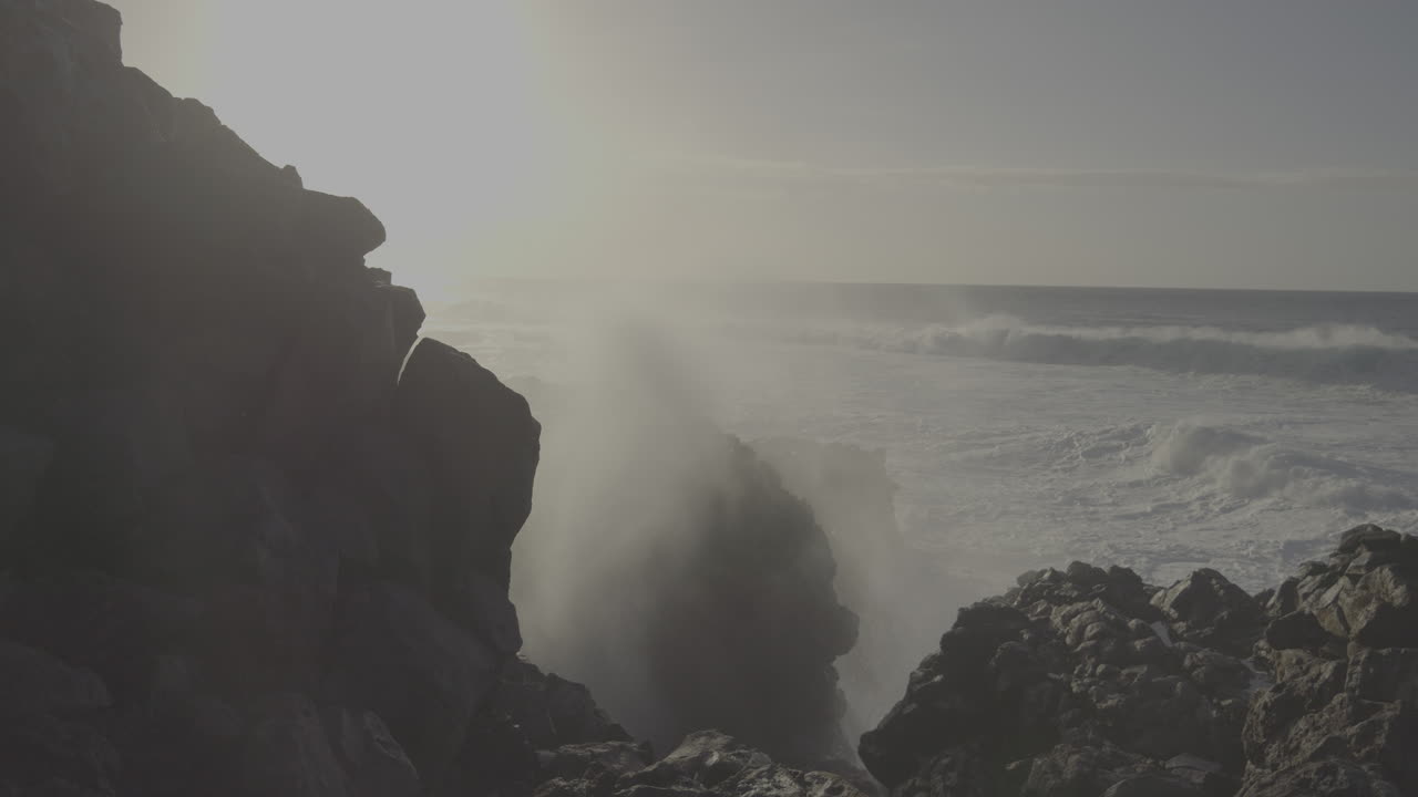 강력한 파도가 있는 바위가 있는 해안선