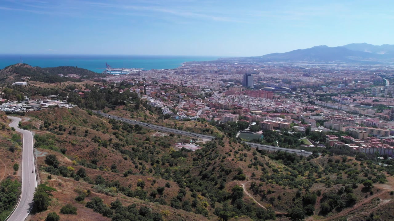 Veduta aerea della città di Malaga e delle colline circostanti, che si sposta lentamente lateralmente, Andalusia, Spagna.