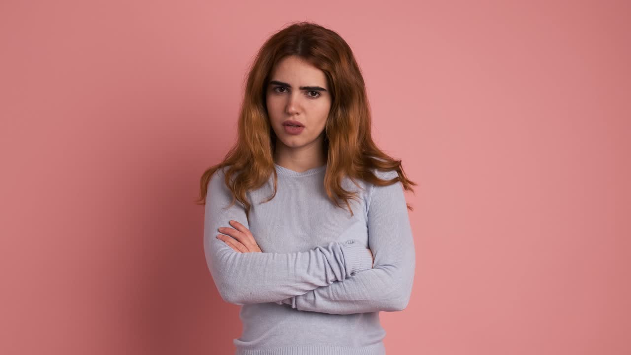 Young woman crossing arms while gesturing negation with head