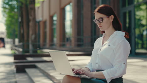 business woman working on a laptop outside