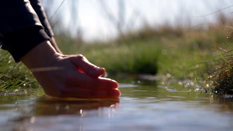 Eine-Person,-Die-Sich-Mit-Reinem-Wasser-Aus-Einer-Flussquelle-Erfrischt