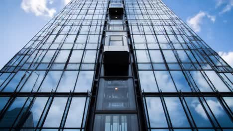 a stunning architectural perspective featuring a modern high-rise building with reflective glass facade and innovative elevator design in urban landscape