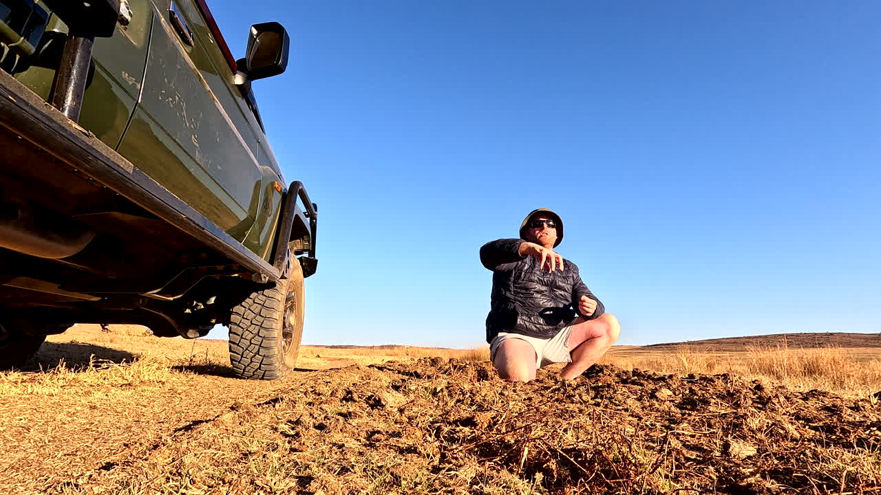 Field guide on safari explains to tourists how rhinos use dung to mark territory